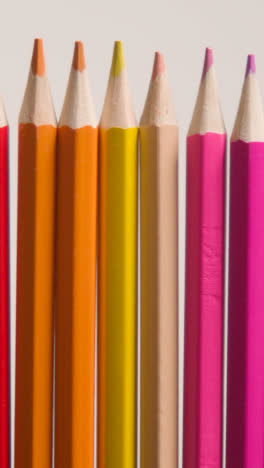 Vertical-Video-Studio-Shot-Of-Multi-Coloured-Pencils-In-A-Line-On-White-Background-